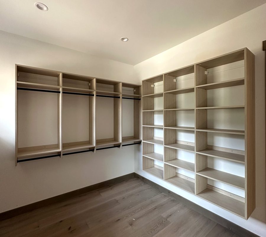 Walk-in closet with hanging sections and tall shelving